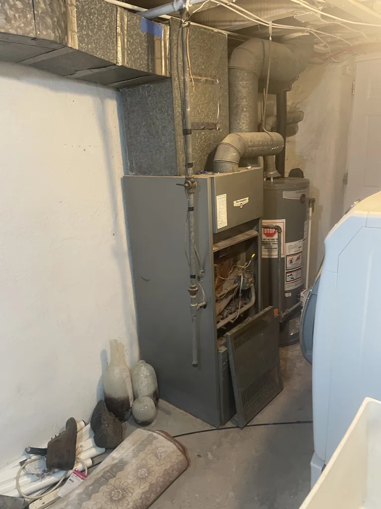 Gas furnace in a basement utility room, serviced by JJC International